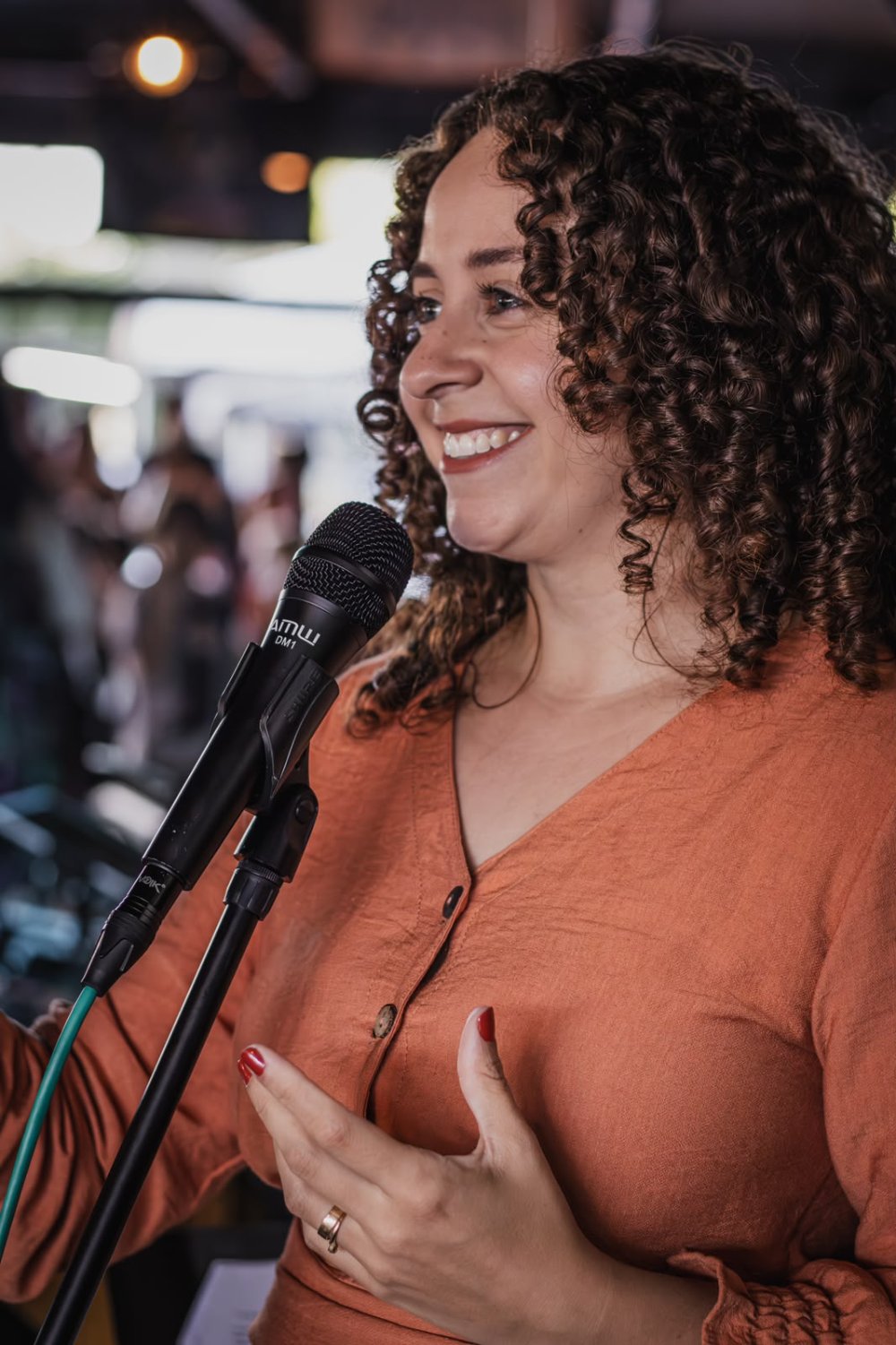 Thayane Chlad, fundadora da Magnificat, cantando ao microfone